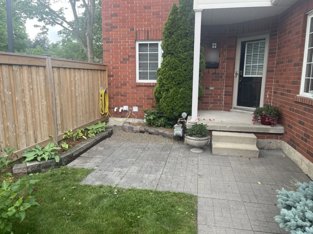 After: front entry with a freshly planted garden border along the fence in Waterdown