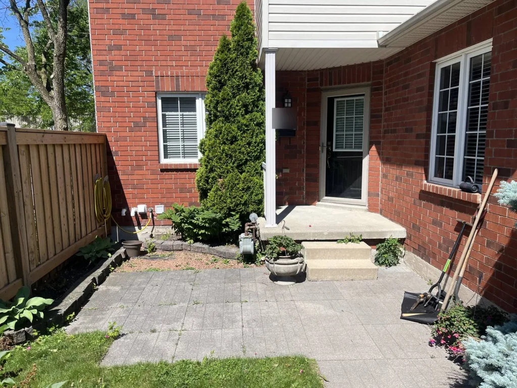 Before: bare front entry with weedy edges and an empty garden border in Waterdown